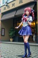 A girl in a school uniform standing in front of a building.