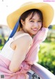 A woman wearing a straw hat and a pink dress.